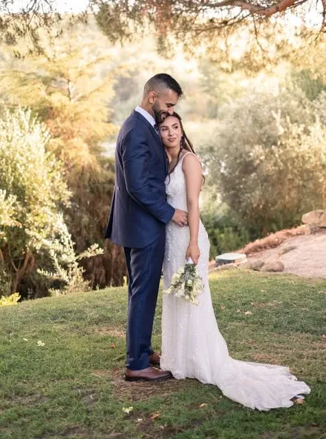 Casal de noivos abraçado num jardim